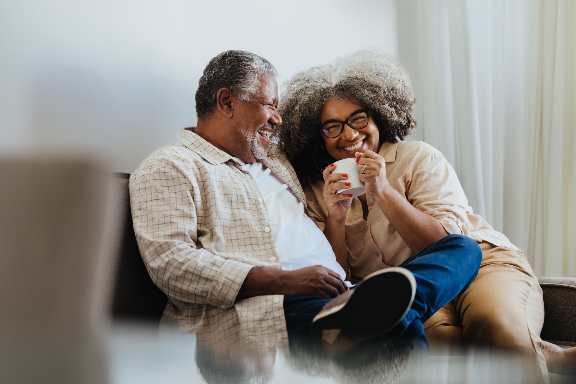 Happy senior couple enjoying coffee together at home